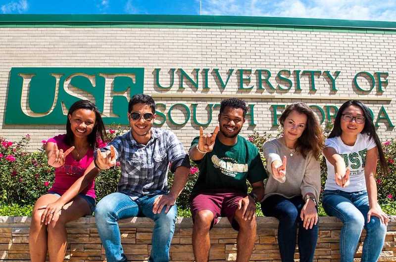 Medium into usf intocenter students infront usf sign bullhorn hand gestures